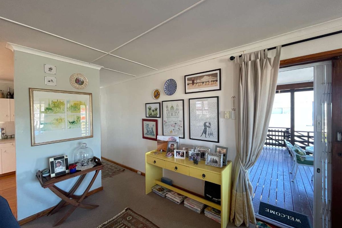 A living area featuring neutral walls, carpeted flooring, and sliding door access to an outdoor patio space.