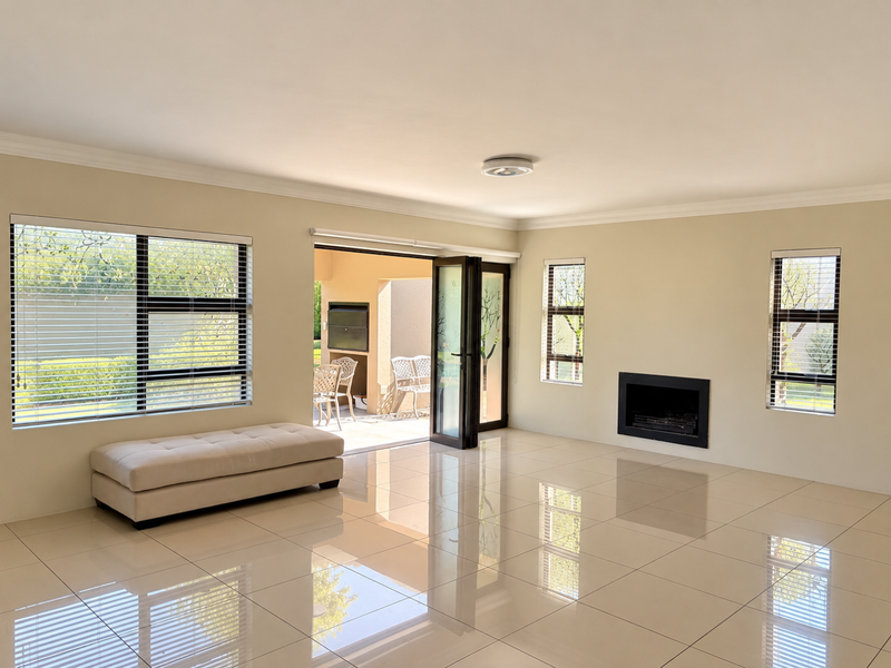 Spacious living room featuring large format floor tiles, a built-in fireplace, and seamless access to an outdoor patio through stacker doors.
