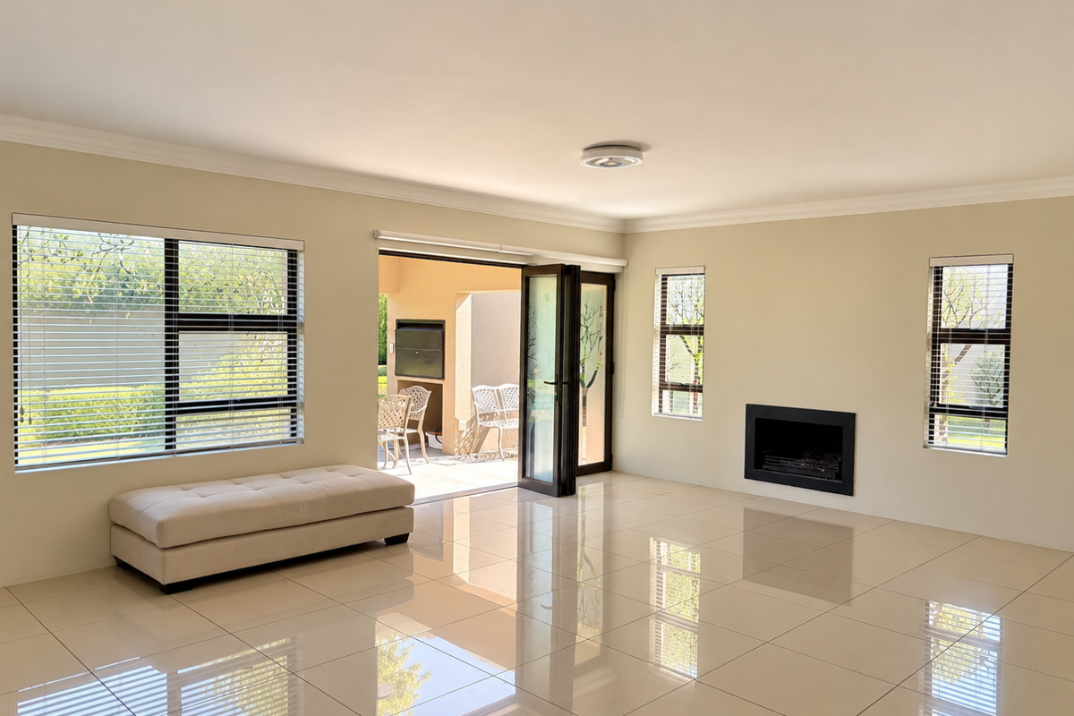 Spacious living room featuring large format floor tiles, a built-in fireplace, and seamless access to an outdoor patio through stacker doors.