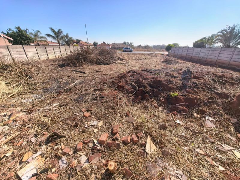 A vacant residential plot featuring precast concrete boundary walls, currently requiring site clearing and landscaping.