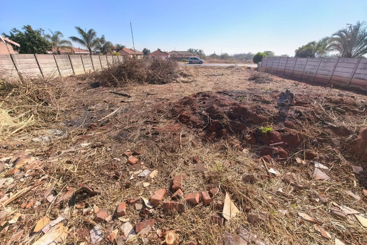 A vacant residential plot featuring precast concrete boundary walls, currently requiring site clearing and landscaping.