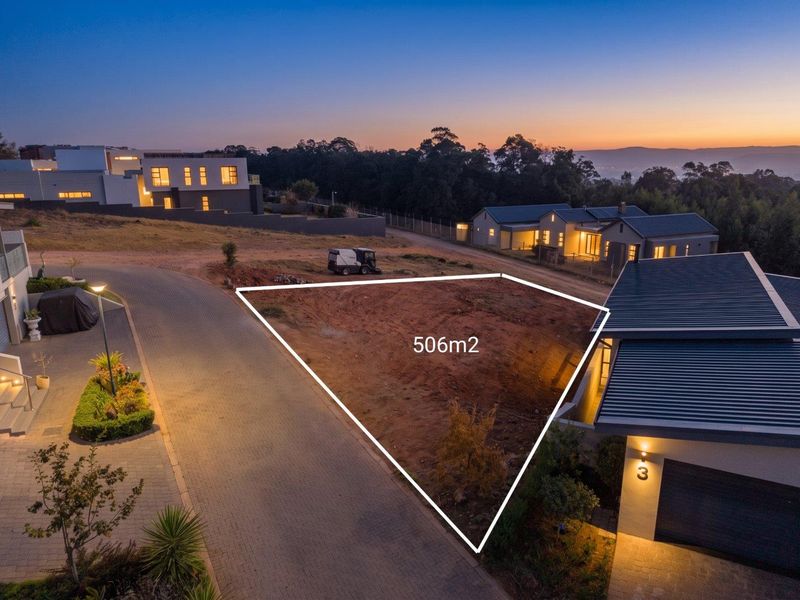An aerial view of a 506m2 vacant residential plot situated in a developed estate, featuring paved road access and surrounding modern residential properties.