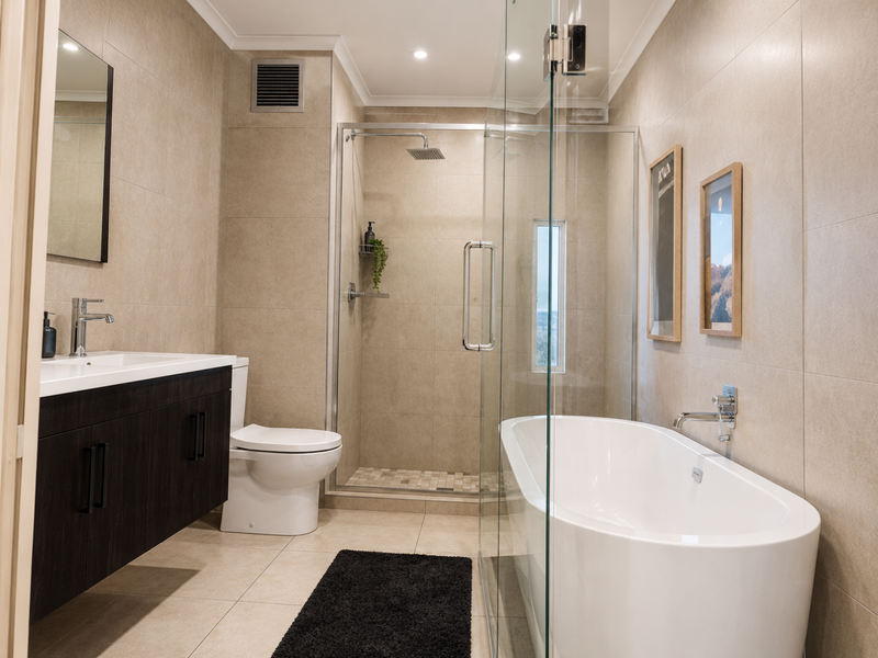 Modern bathroom featuring a floating vanity, glass-enclosed shower with rain head, and a sleek freestanding bathtub with contemporary wall-mounted fixtures.