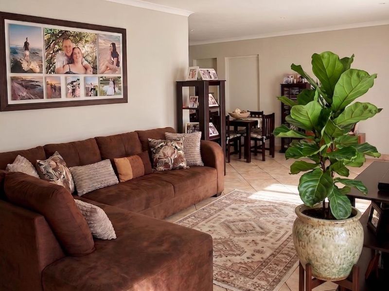 An open-plan living and dining area featuring neutral wall tones and tiled flooring, providing a functional and connected space for daily living.
