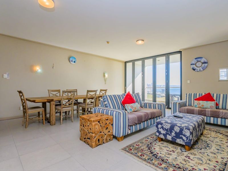 Spacious open-plan living and dining area featuring neutral tiled flooring and large sliding glass doors that provide access to the balcony.
