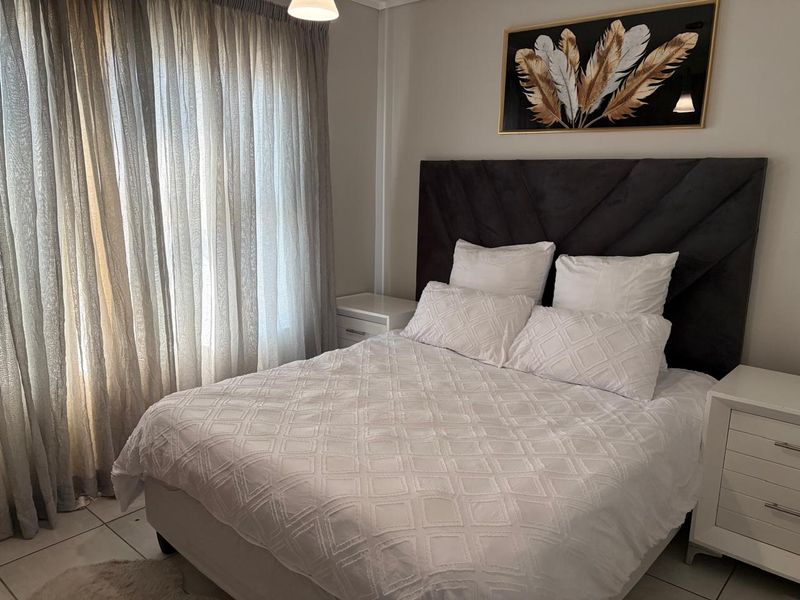 A well-maintained bedroom featuring tiled flooring and neutral wall finishes, providing a clean and comfortable living space.