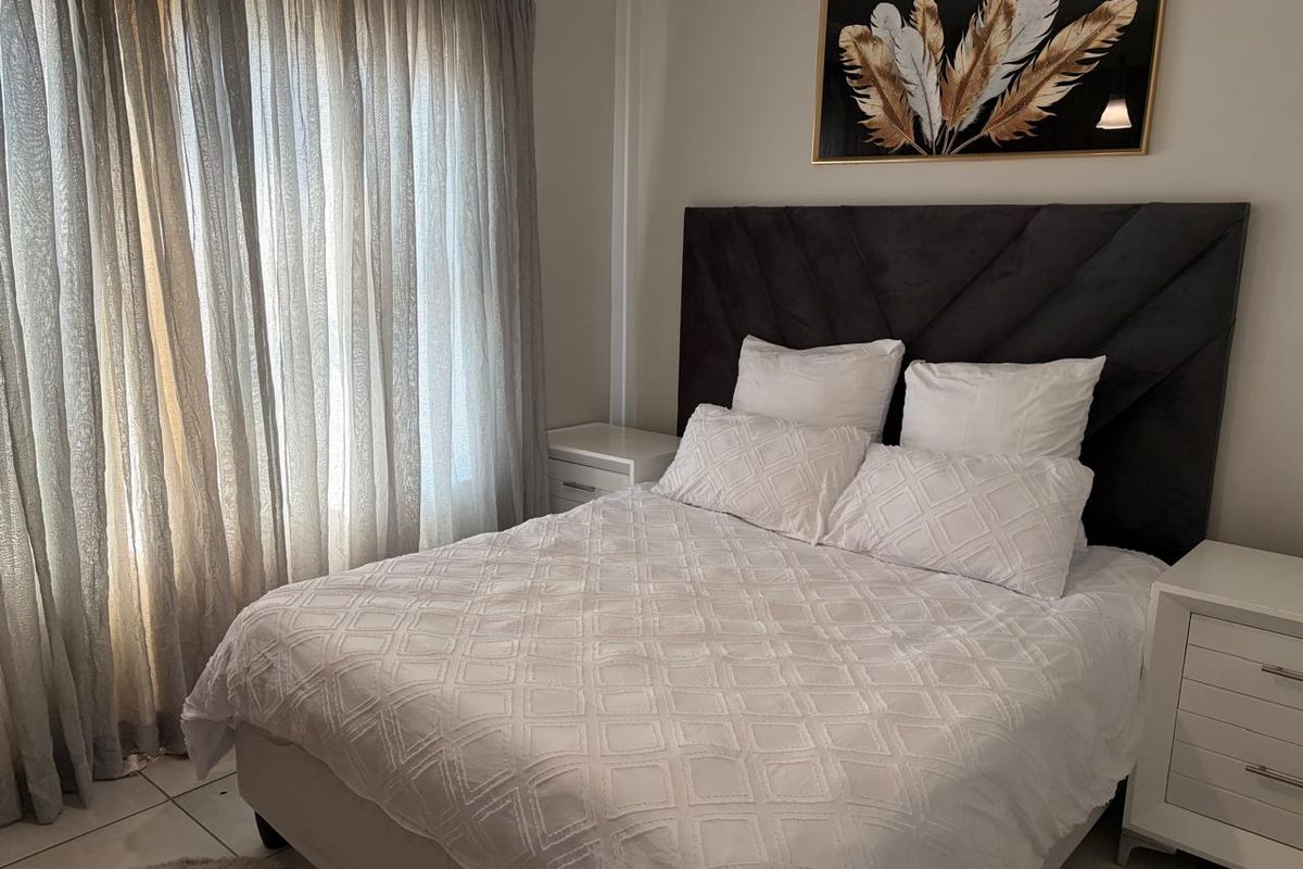 A well-maintained bedroom featuring tiled flooring and neutral wall finishes, providing a clean and comfortable living space.