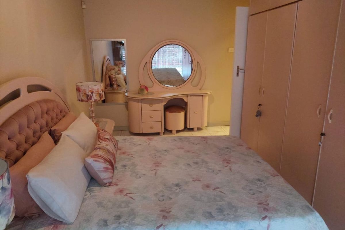 A bedroom featuring built-in cupboards and tiled flooring, providing a functional space with neutral wall finishes.