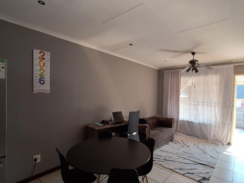 Open plan living area featuring tiled flooring, recessed lighting, a ceiling fan, and direct access to an outdoor space through a glass panel door.