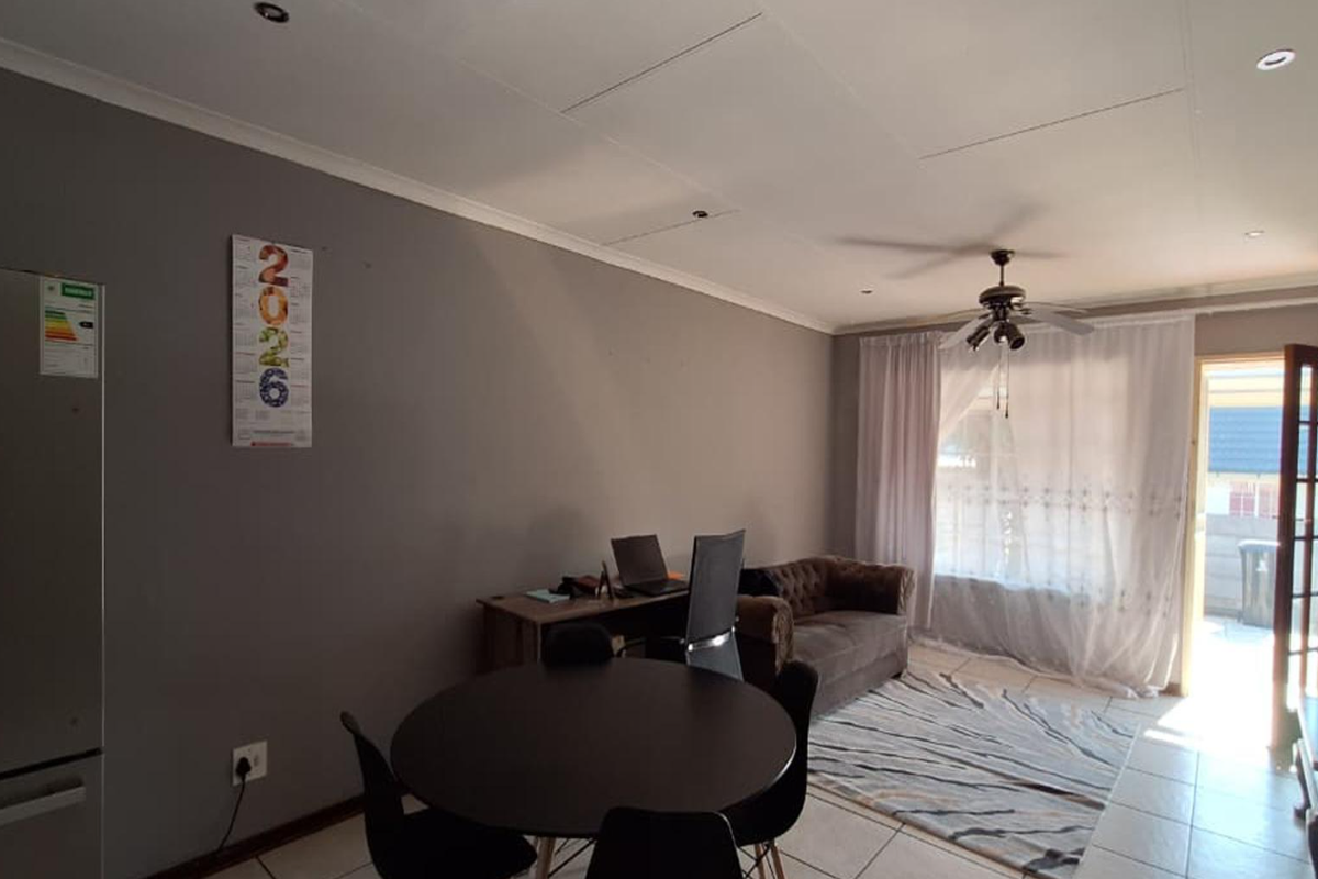 Open plan living area featuring tiled flooring, recessed lighting, a ceiling fan, and direct access to an outdoor space through a glass panel door.