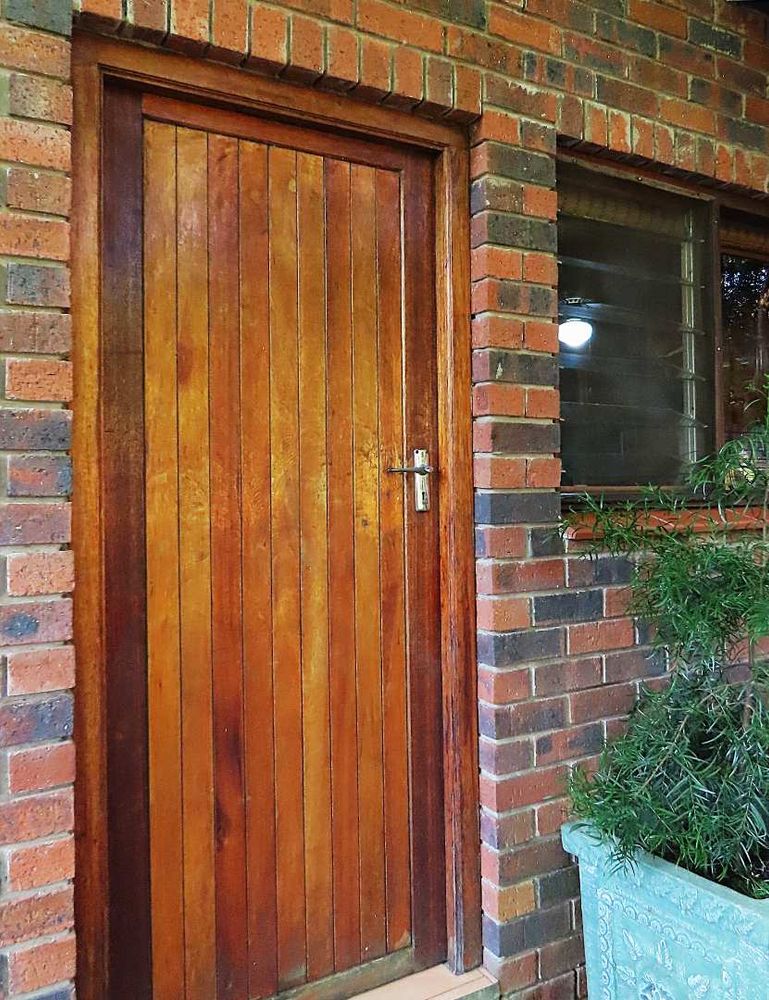 Seperate laundry and back door leading onto a paved back garden area.