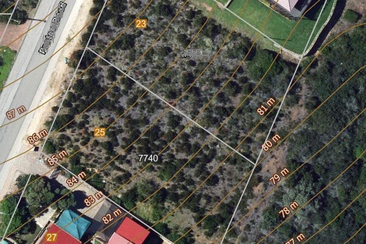 Aerial view of a vacant residential plot featuring topographical contour lines and property boundary markers.