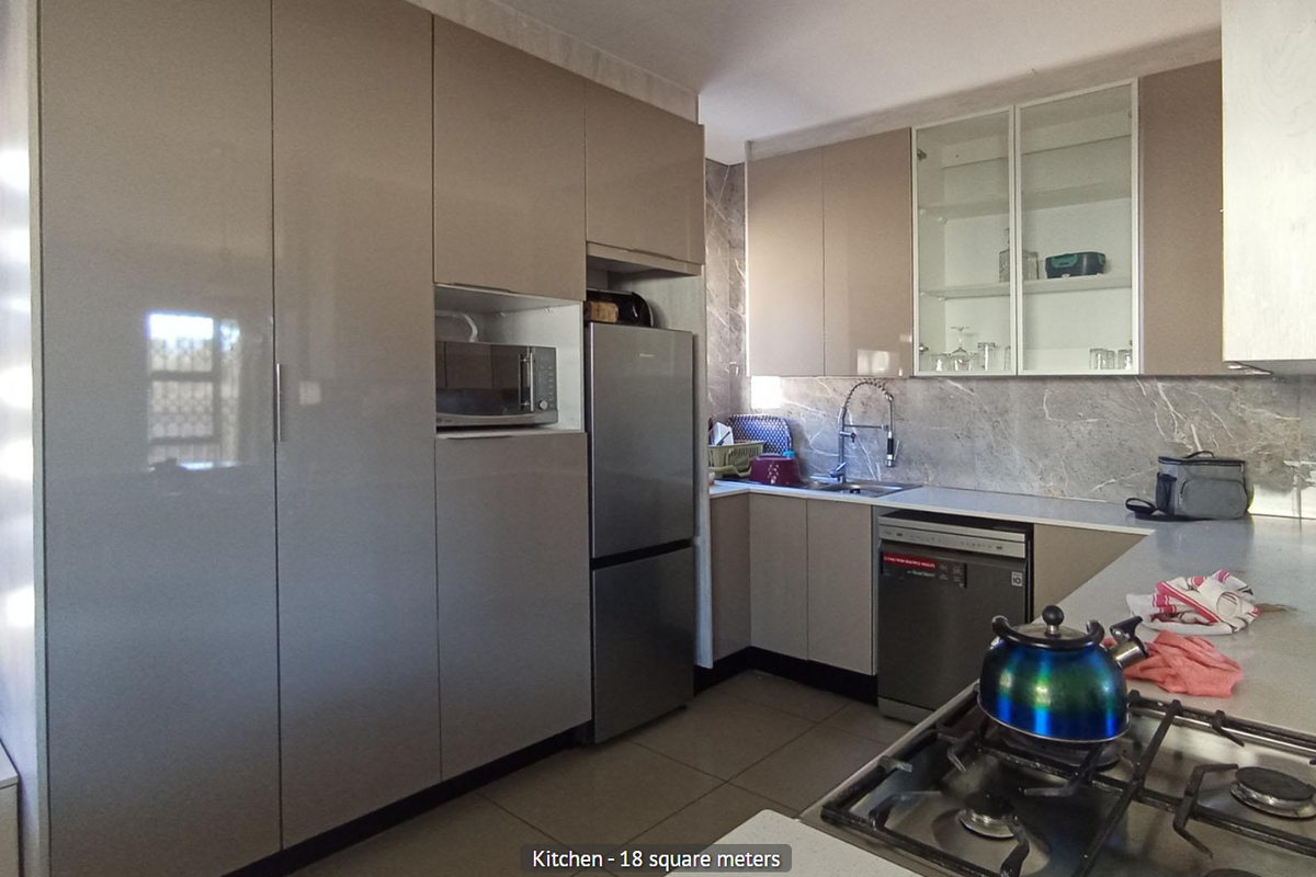 Modern kitchen featuring sleek cabinetry, stone-look backsplash, integrated microwave, stainless steel dishwasher, and a gas hob.