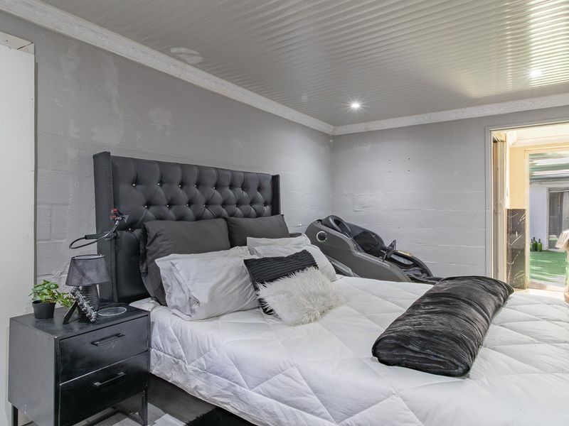 A bedroom featuring a panelled ceiling with recessed lighting and coved detailing, requiring cosmetic attention to the wall finishes.