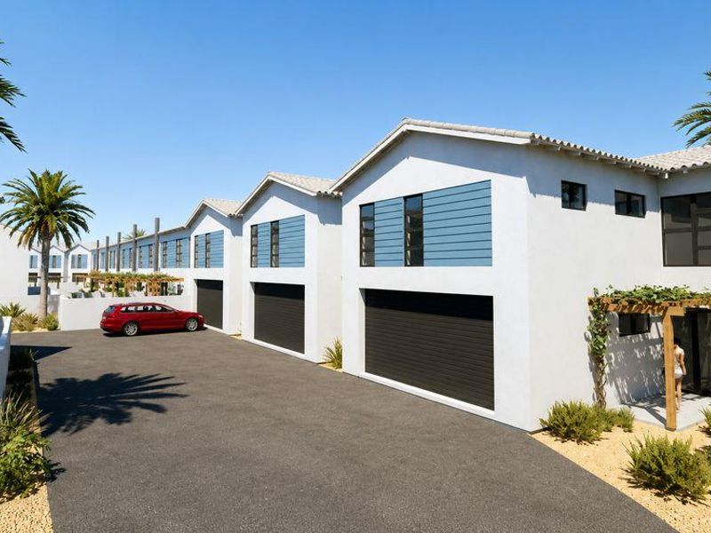 A modern townhouse complex featuring a paved driveway, integrated garages, and timber pergola accents, showcasing a clean and contemporary architectural design.