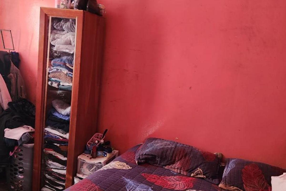 A bedroom featuring tiled flooring and painted walls, requiring cosmetic updates to improve the overall aesthetic and condition of the space.