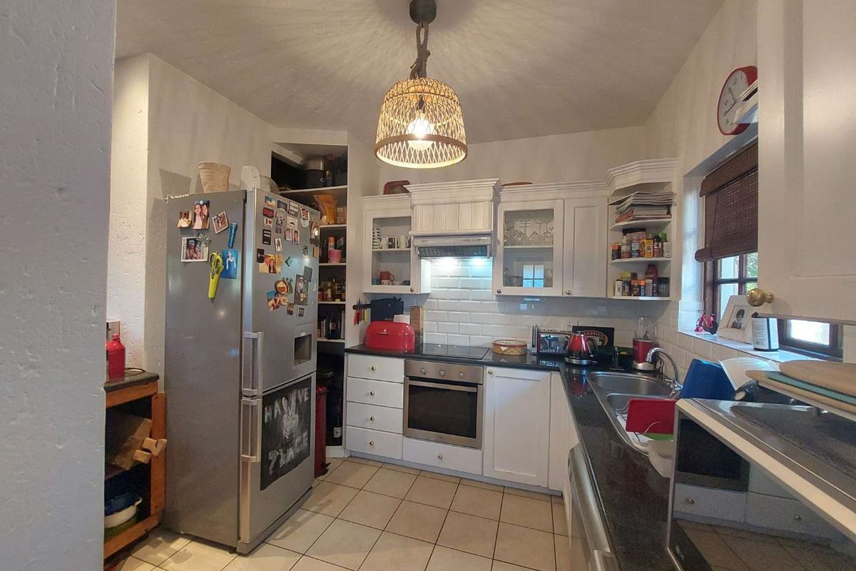 A functional kitchen featuring white cabinetry, subway tile backsplash, dark countertops, and ceramic floor tiles, providing a practical workspace for daily cooking.