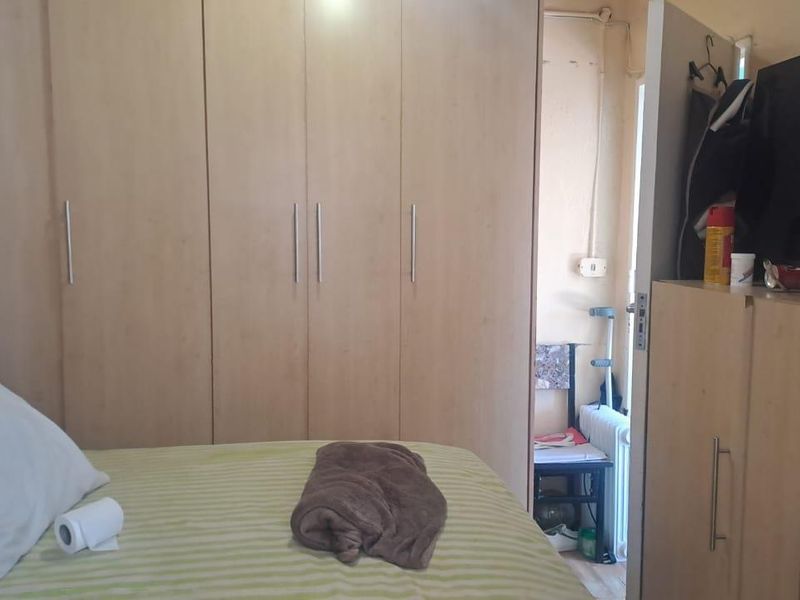 A bedroom featuring built-in wooden wardrobes providing ample storage space.