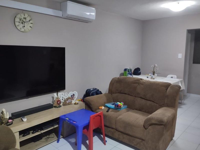 A living room featuring tiled flooring and a wall-mounted split-system air conditioning unit.