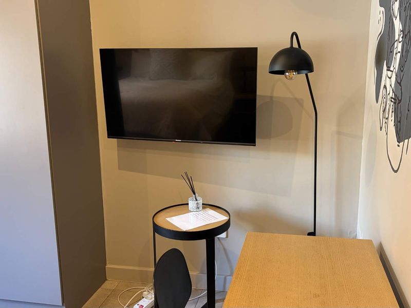 A bedroom interior featuring a built-in wardrobe and a wall-mounted television.