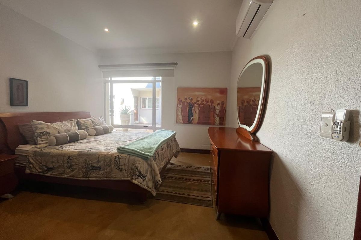 A bedroom featuring a split-system air conditioner, recessed lighting, and a sliding glass door providing access to an outdoor area.