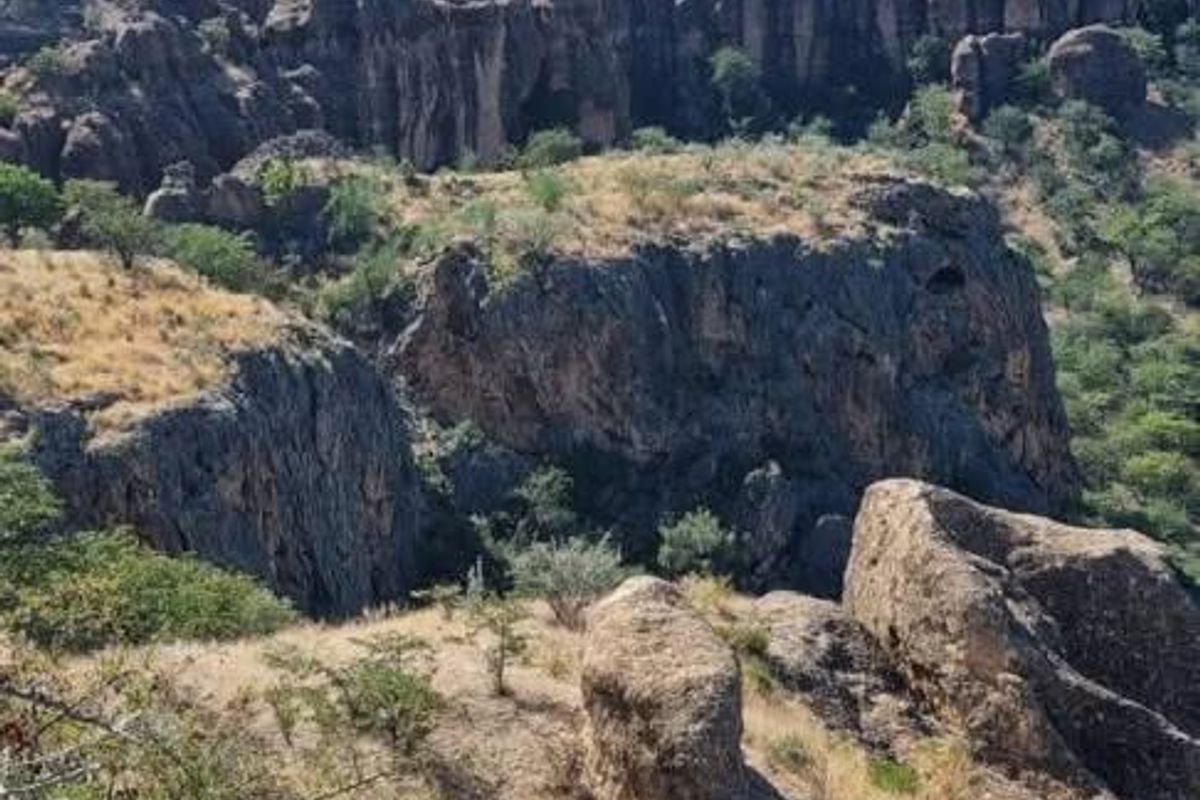 A scenic view of the rugged natural landscape and rocky cliff formations surrounding the farm property.