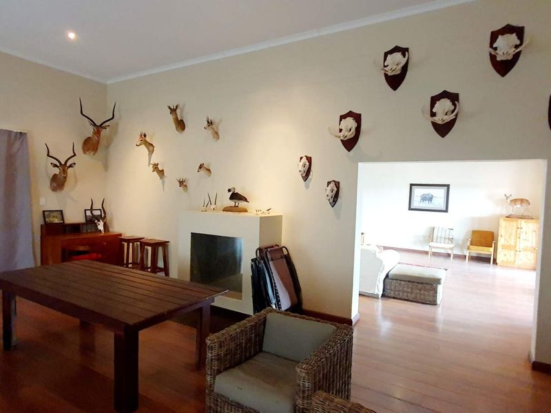 Spacious living area featuring hardwood flooring, a built-in fireplace, and recessed lighting, with an open transition to an adjacent room.