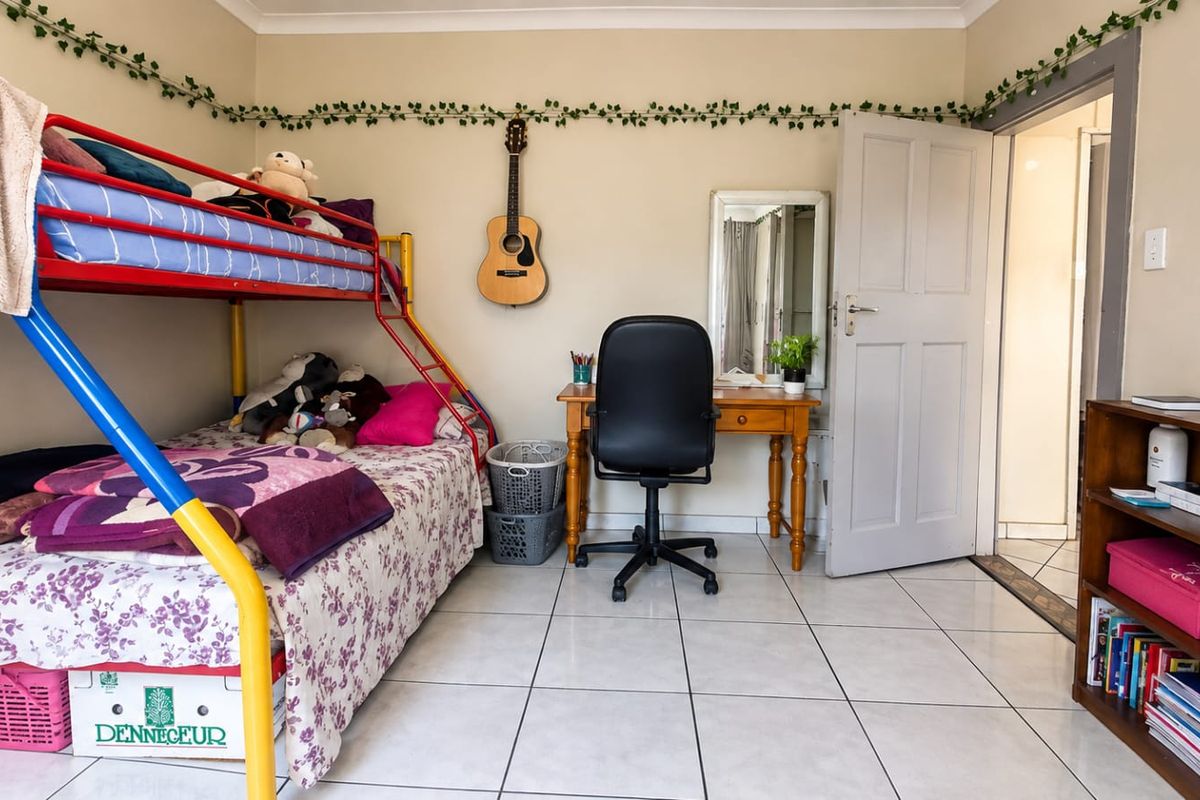 A functional bedroom featuring tiled flooring and neutral wall finishes, providing a versatile space for rest or study.
