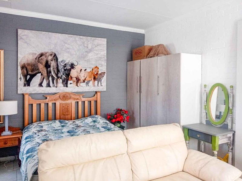 A bedroom featuring a painted brick accent wall and a built-in wardrobe, offering a functional space with potential for modern updates.