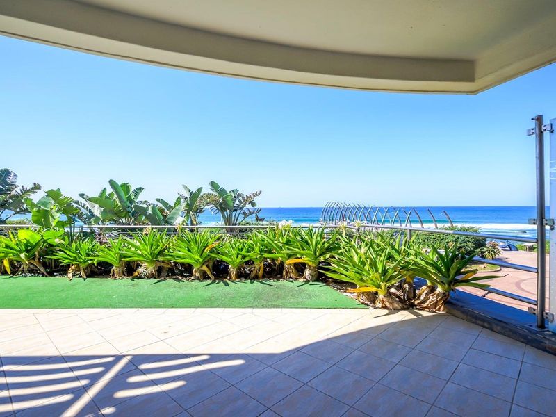 Spacious balcony featuring tiled flooring, a glass balustrade, and panoramic ocean views, providing an ideal outdoor space for relaxation.
