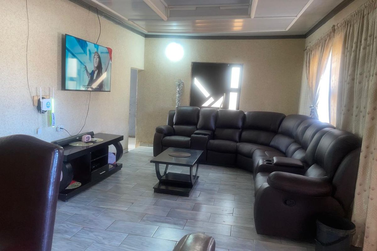A living room featuring tiled flooring and a recessed ceiling, providing a functional space for relaxation.