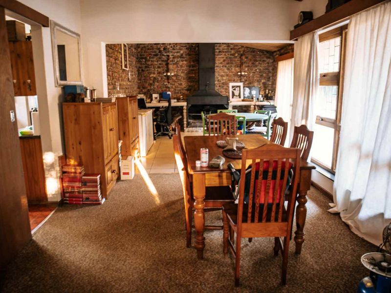 Open plan living and dining area featuring an exposed brick wall, built-in fireplace, and direct access to the outdoors via sliding glass doors.