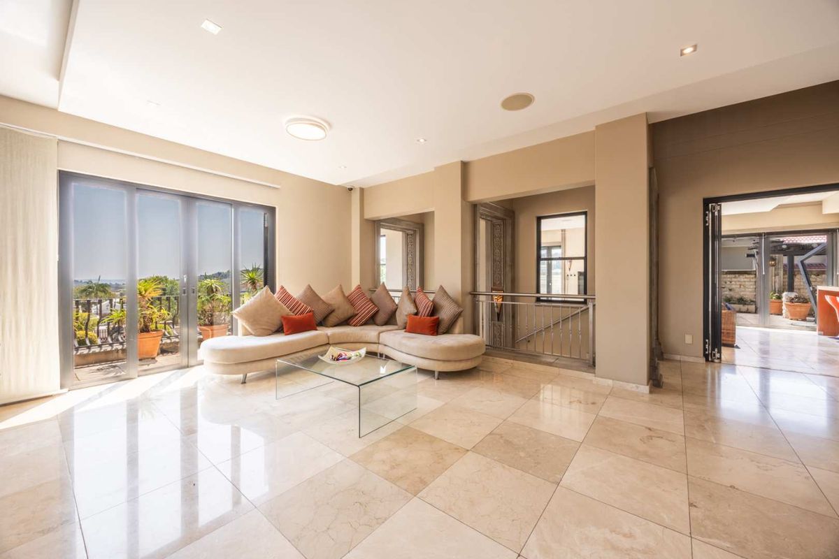 Spacious living area featuring polished stone tile flooring, recessed lighting, and large sliding glass doors that open to an outdoor balcony.