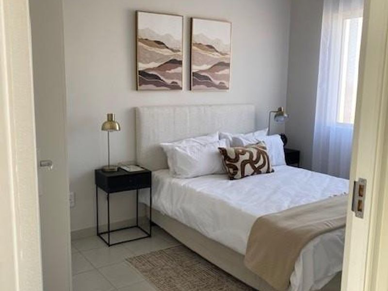 A well-maintained bedroom featuring neutral wall tones, tiled flooring, and a coved ceiling, offering a clean and comfortable living space.