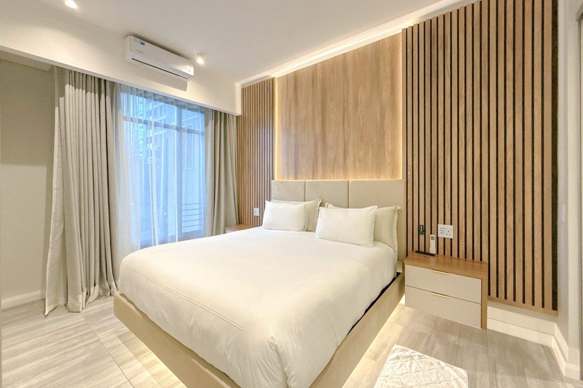Modern bedroom featuring contemporary timber slat wall paneling, integrated LED accent lighting, and a wall-mounted air conditioning unit.