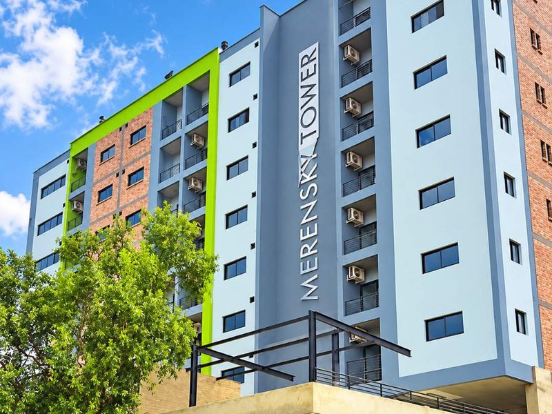 Exterior view of Merensky Tower, a multi-story apartment building featuring a modern facade with balconies and integrated air conditioning units.