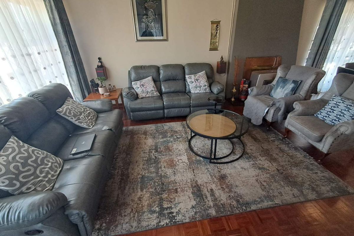 A comfortable living room featuring classic parquet flooring and a built-in fireplace, offering a warm and inviting space for relaxation.