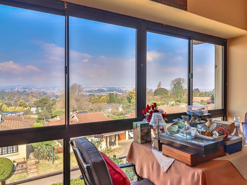 Enclosed balcony area featuring expansive sliding glass windows that provide panoramic views of the surrounding neighborhood and landscape.