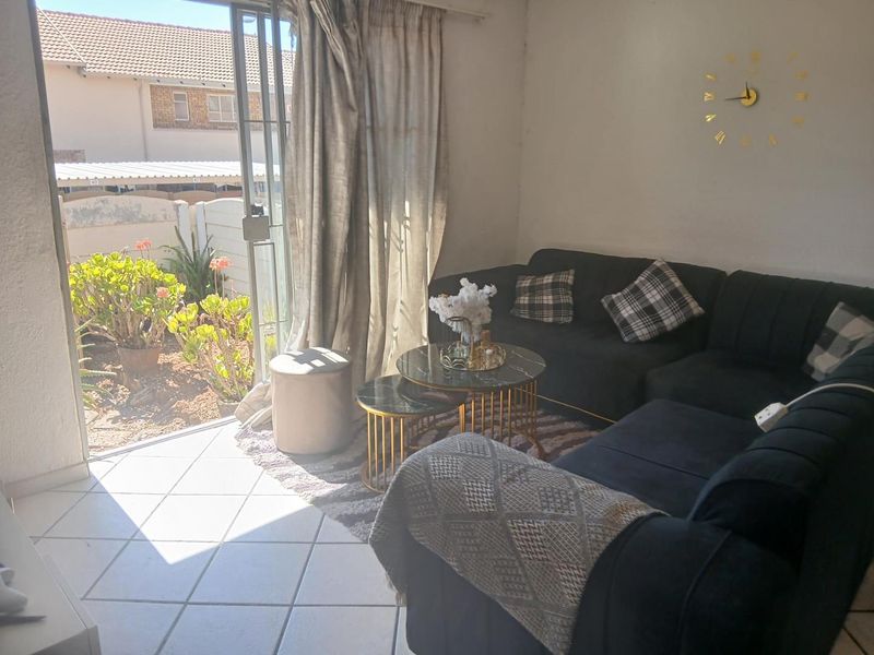 A living room featuring ceramic floor tiles and a large sliding glass door providing direct access to the outdoor area.