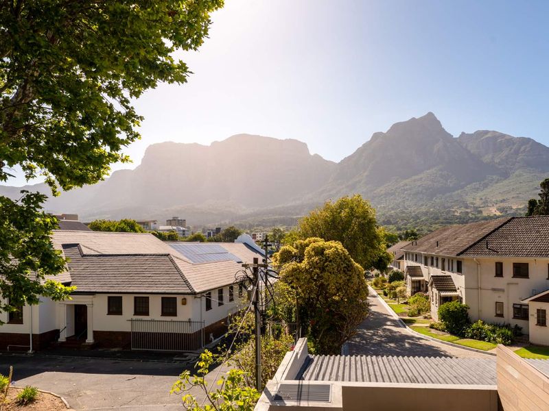 Elevated view overlooking the surrounding residential complex with prominent mountain scenery in the background.