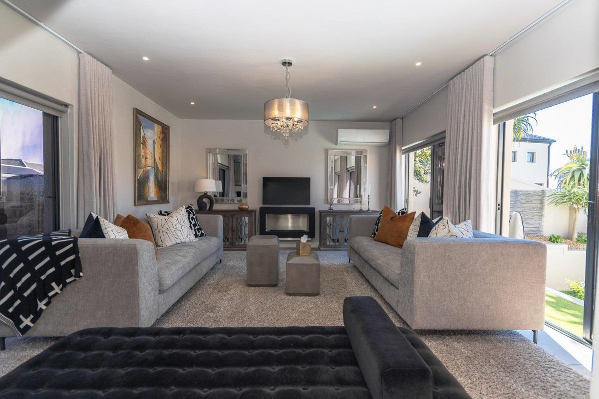 A well-appointed living room featuring a built-in fireplace, split-system air conditioning, and large sliding glass doors that provide access to the outdoor area.