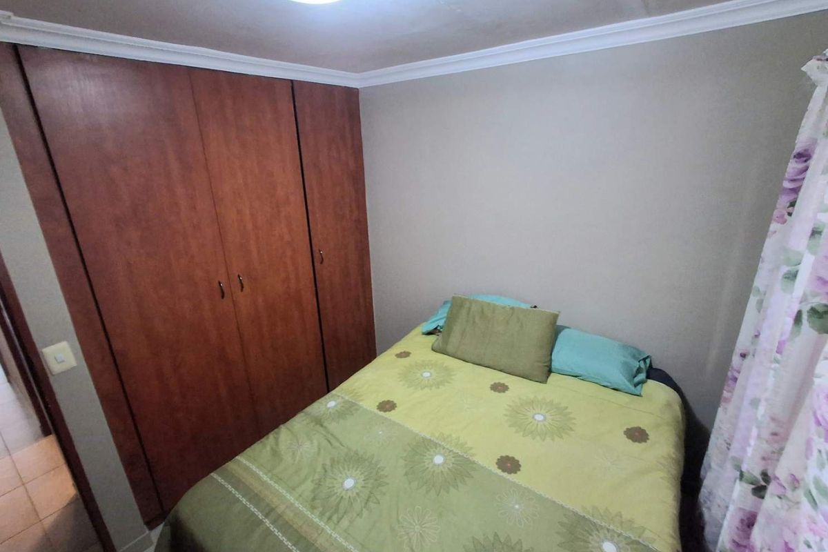 A bedroom featuring built-in wooden cupboards and crown molding, providing functional storage space.