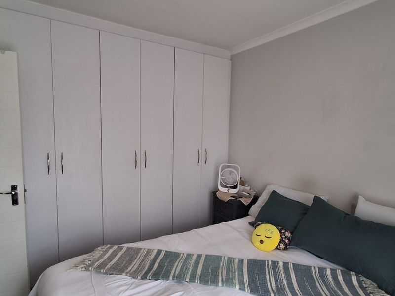 A bedroom featuring neutral walls and extensive floor-to-ceiling built-in cupboards providing ample storage space.