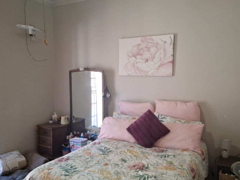 A standard bedroom featuring neutral wall finishes and decorative coving, currently requiring minor electrical maintenance for exposed wiring.