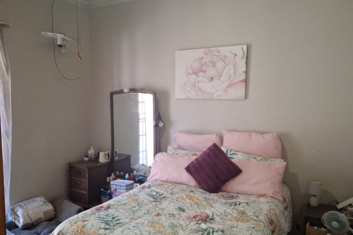 A standard bedroom featuring neutral wall finishes and decorative coving, currently requiring minor electrical maintenance for exposed wiring.