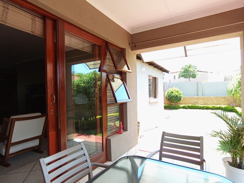 A covered patio area featuring tiled flooring and large sliding glass doors providing seamless access to the interior living space.