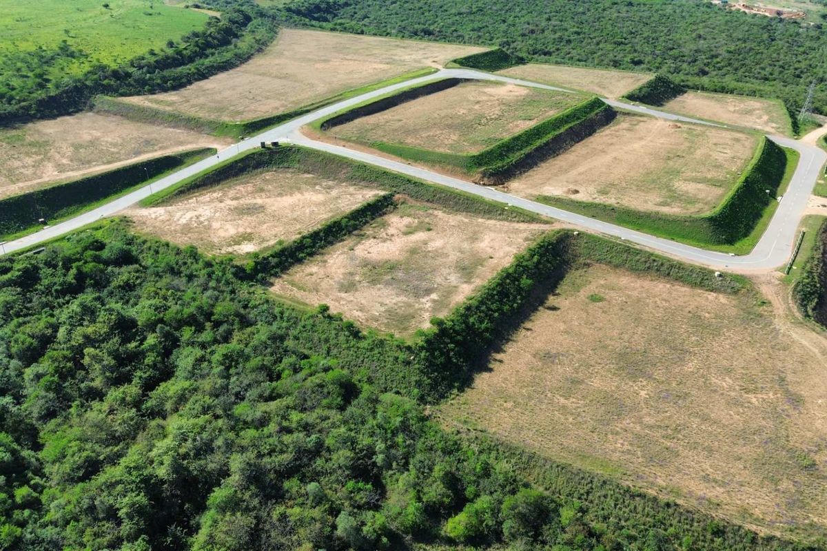 Aerial view of an industrial development site featuring cleared, terraced land plots with established paved access roads and surrounding natural vegetation.