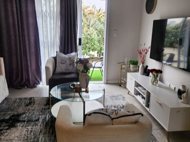 A comfortable living room featuring tiled flooring and a sliding glass door that provides direct access to an outdoor patio area.