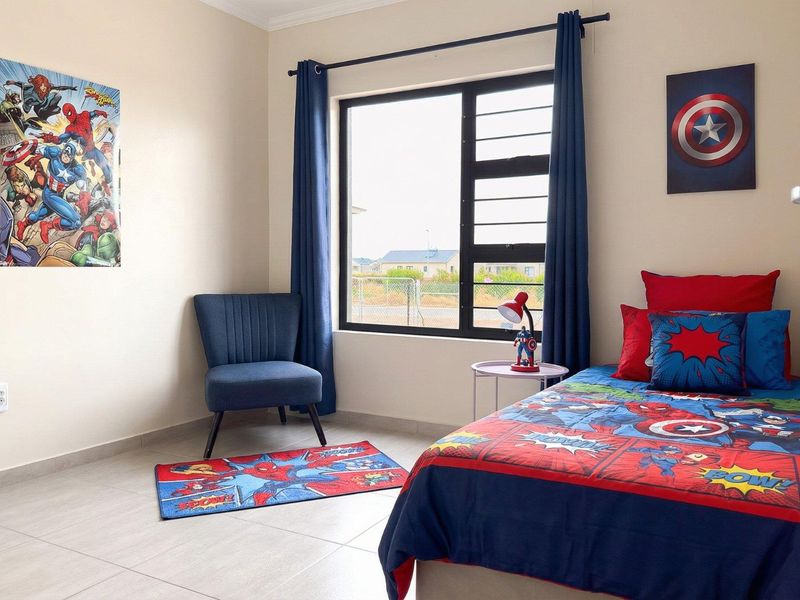 A well-maintained bedroom featuring neutral tiled flooring, clean wall finishes, and a large aluminium-framed window providing natural light.
