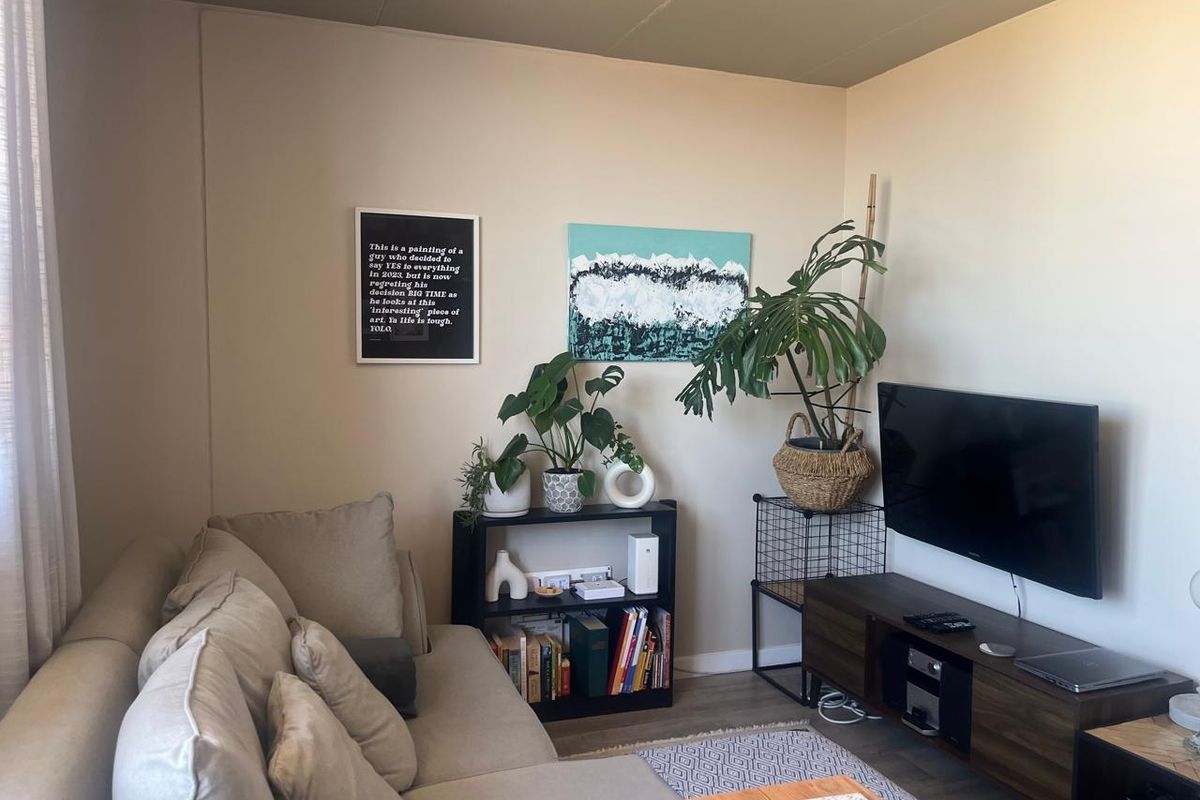 A cozy living room featuring neutral wall tones and laminate flooring, providing a comfortable and functional space for relaxation.